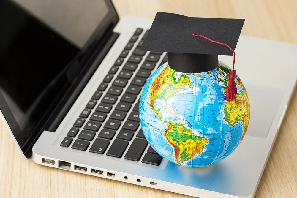 high-angle-globe-with-academic-cap-laptop copy